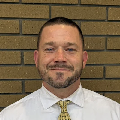 Michael Livingston smiling in a white shirt and tie.